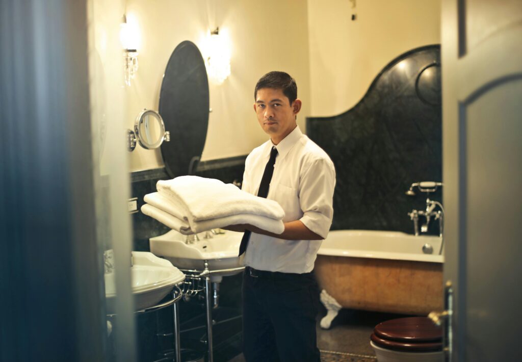 Man Holding Bath Towels Near Bathtub