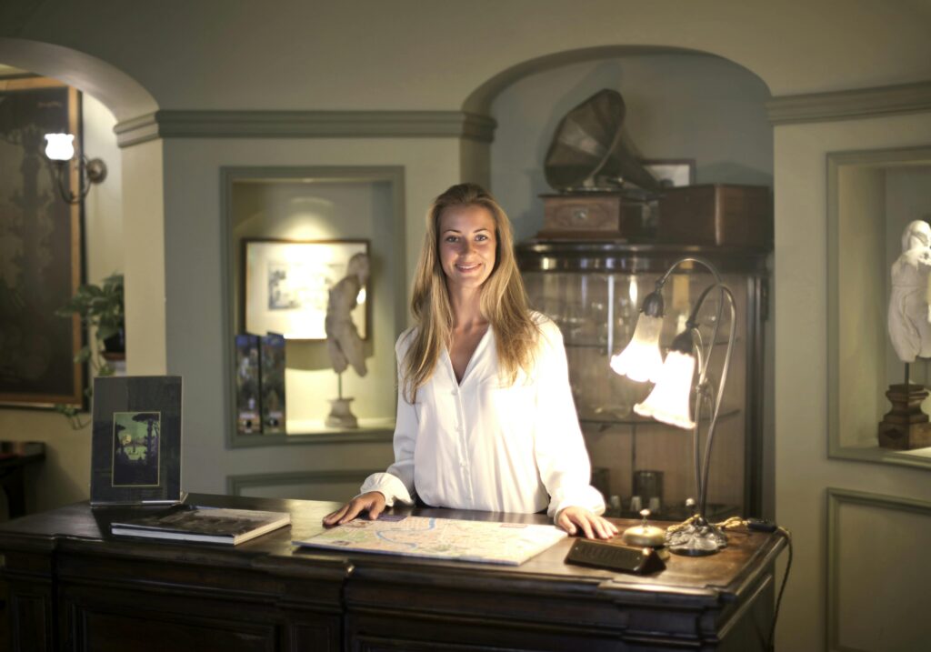 Hospitable Woman Standing Behind Front Desk